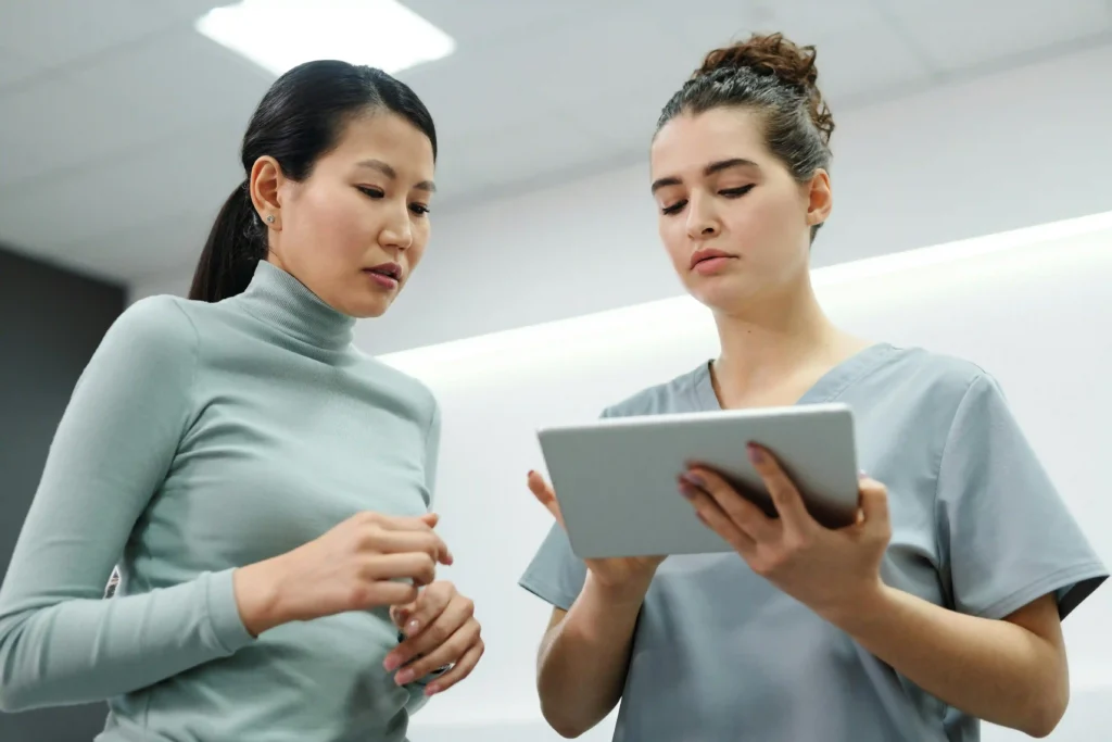 Two people reviewing health information on a digital tablet in a modern indoor setting